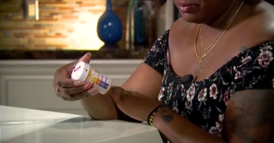 Timika Thomas looks at a prescription bottle as she describes her ordeal. (KLAS)