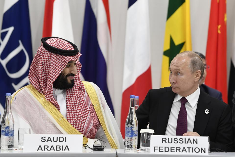 FILE - Saudi Arabia's Crown Prince Mohammed bin Salman, left, talks with Russian President Vladimir Putin, right, during the G-20 summit event on the Digital Economy in Osaka, Japan, on June 28, 2019. Putin has forged strong personal ties with Saudi Crown Prince Mohammed bin Salman, helping strike an OPEC+ deal to cut oil output. (AP Photo/Susan Walsh, File)
