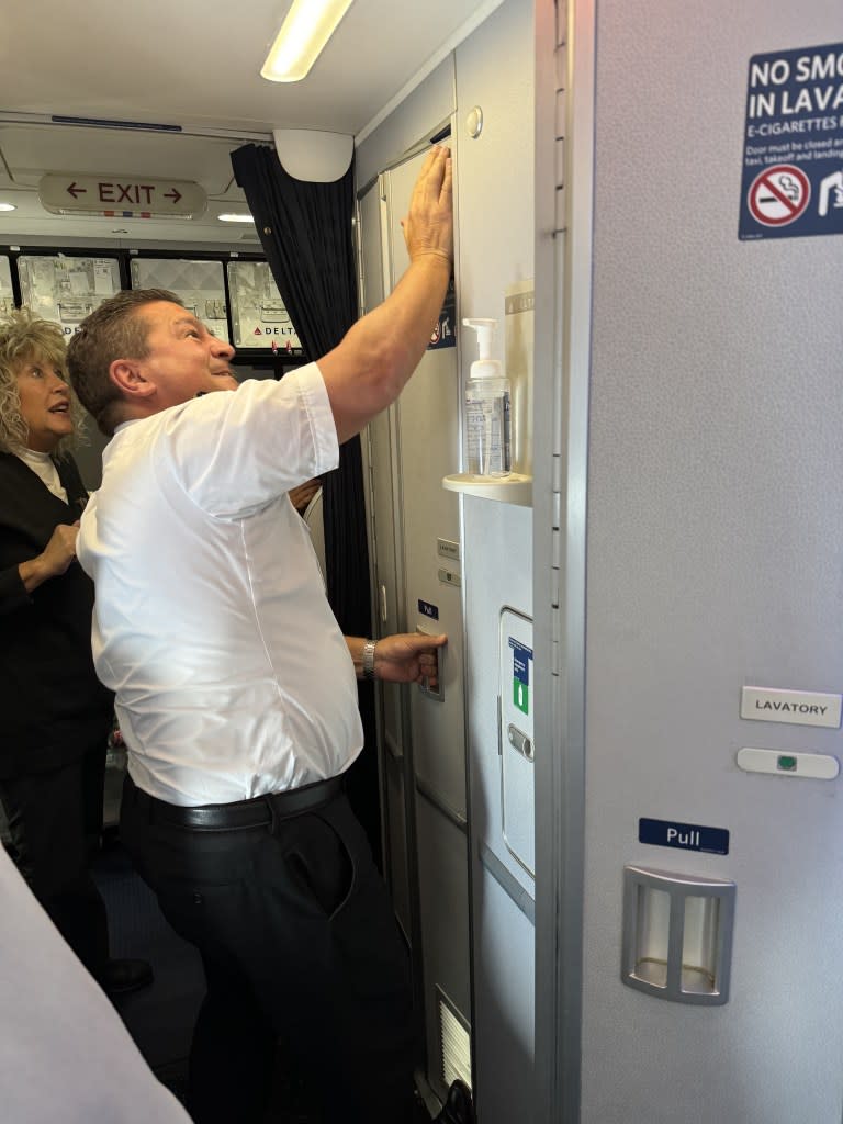“My attention diverted to the rear of the plane, where sure enough, two Delta flight attendants were yanking the bathroom door handle in an attempt to free my trapped husband,” the woman wrote. Reddit/StuckDeltaBathroom