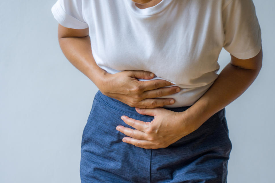 Woman having painful stomachache. Persistence of various GI symptoms can  be a key indicator that you should seek medical attention, regardless of cancer risk. (Getty Images)