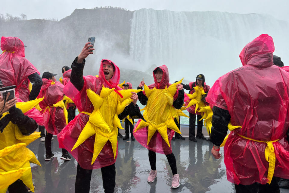 Some of the 309 people gathered to break the Guinness World Record for the largest group of people dressed as the sun pose on a sightseeing boat, before the total solar eclipse in Niagara Falls, Ontario, Canada April 8, 2024.