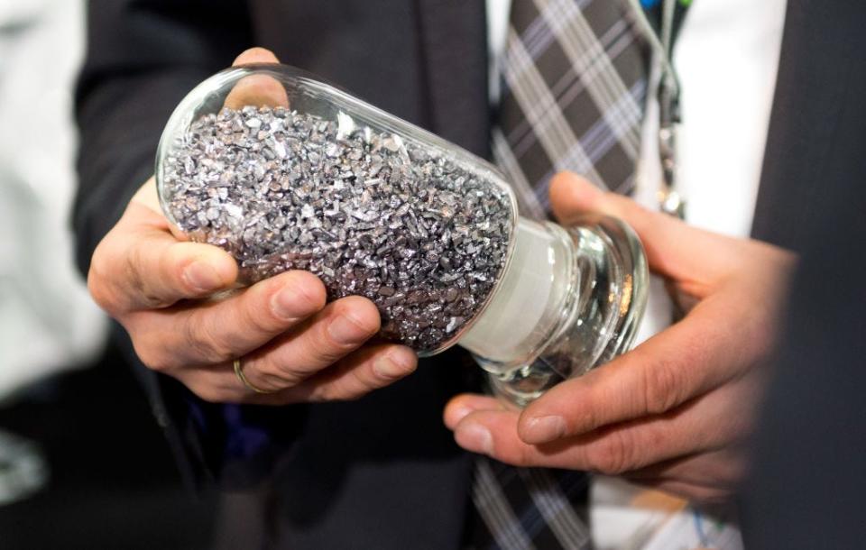 A man holds a sample of tungsten in a glass jar