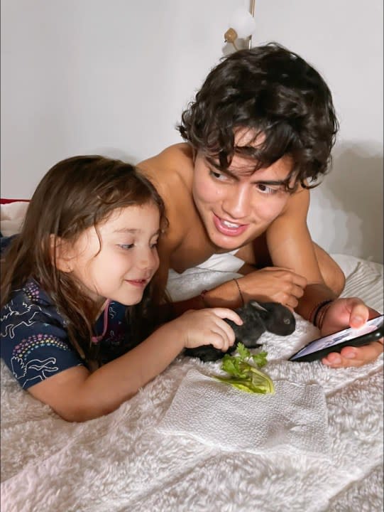 18-year-old Julian Torres petting a rabbit with his seven-year-old sister. (Paulina Flores)