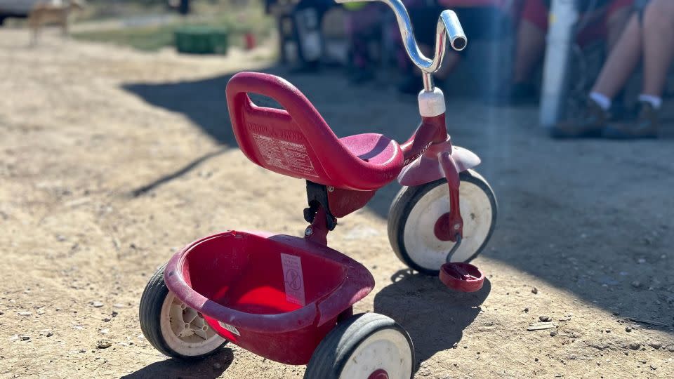 A red tricycle sits in the sun near Arlene Henry's home. - Ashley Killough/CNN