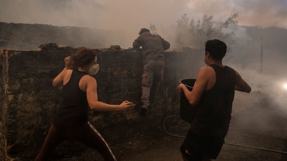 People turned to hoses and buckets to keep fires from consuming their homes, in Albergaria-a-Velha on September 16. - Patricia De Melo Moreira/AFP/Getty Images