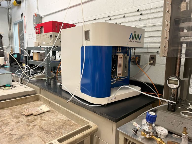 A blue and white machine with wires on a counter against a wall