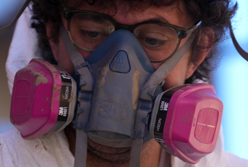 Kent Tweeten wears a respirator as he assists with clearing debris in Marshall, N.C., on Oct. 10, 2024. The city of Marshall experienced flooding caused by the tropical storm winds and rain brought by the remnants of Tropical Storm Helene.