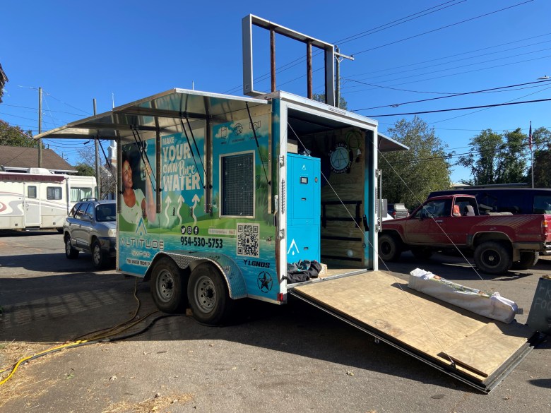 A trailer with water filtering equipment inside and solar panels on the roof.