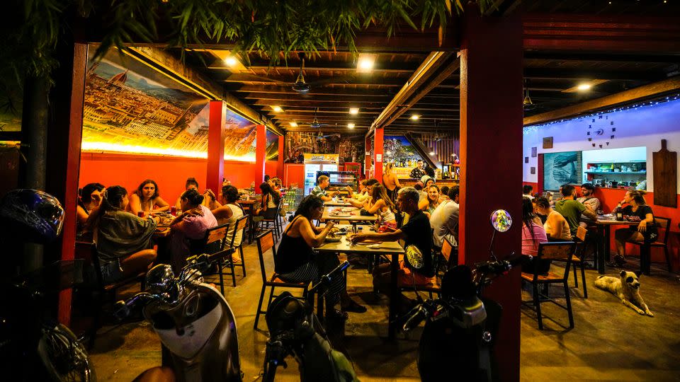 Tourists eat dinner at a hostel in Vang Vieng, Laos, on November 19, 2024. - Anupam Nath/AP