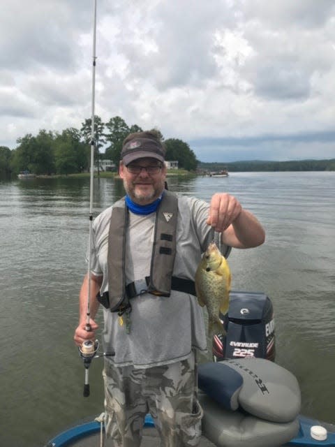 Dennis Fascella Jr. holds up a fish he caught.