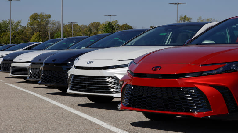 A lineup of Toyota Camry hybrids at a dealership.