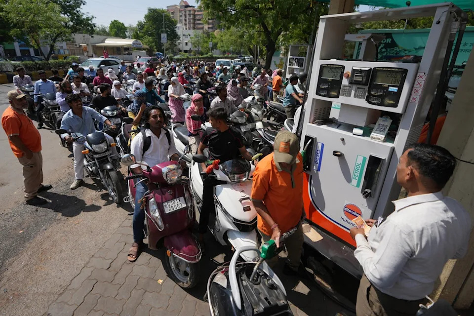 People queue up to get fuel at a pump in Ahmedabad, India, on 23 March 2026 (AP)