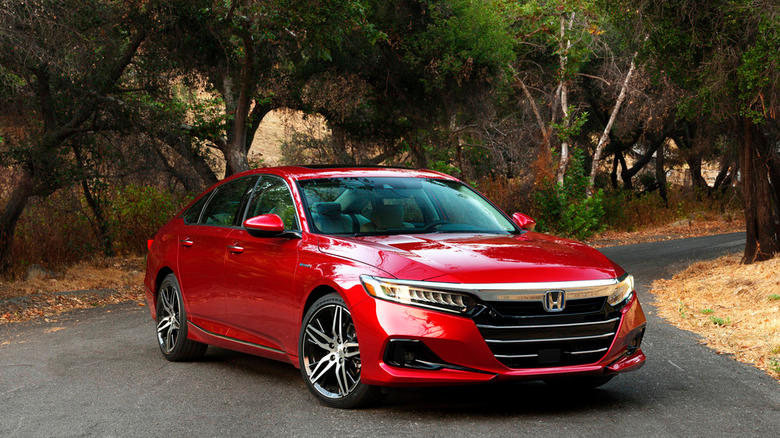 Front shot of a red 2026 Honda Accord Hybrid on a scenic road