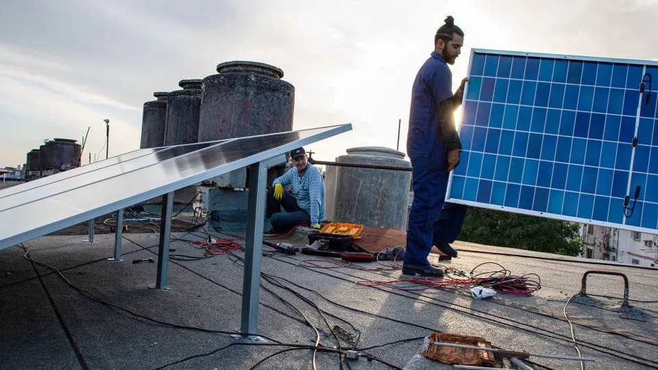 Specialists install solar panels on the rooftop of a multi-family building in Matanzas, Cuba, on April 13, 2026. (Photo by AFP via Getty Images) - AFP/Getty Images